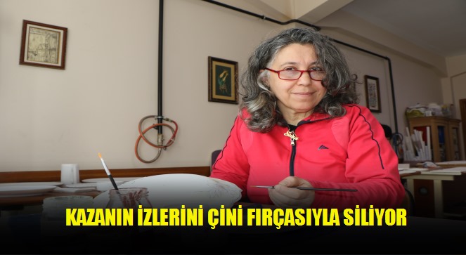 Kazanın izlerini çini fırçasıyla siliyor